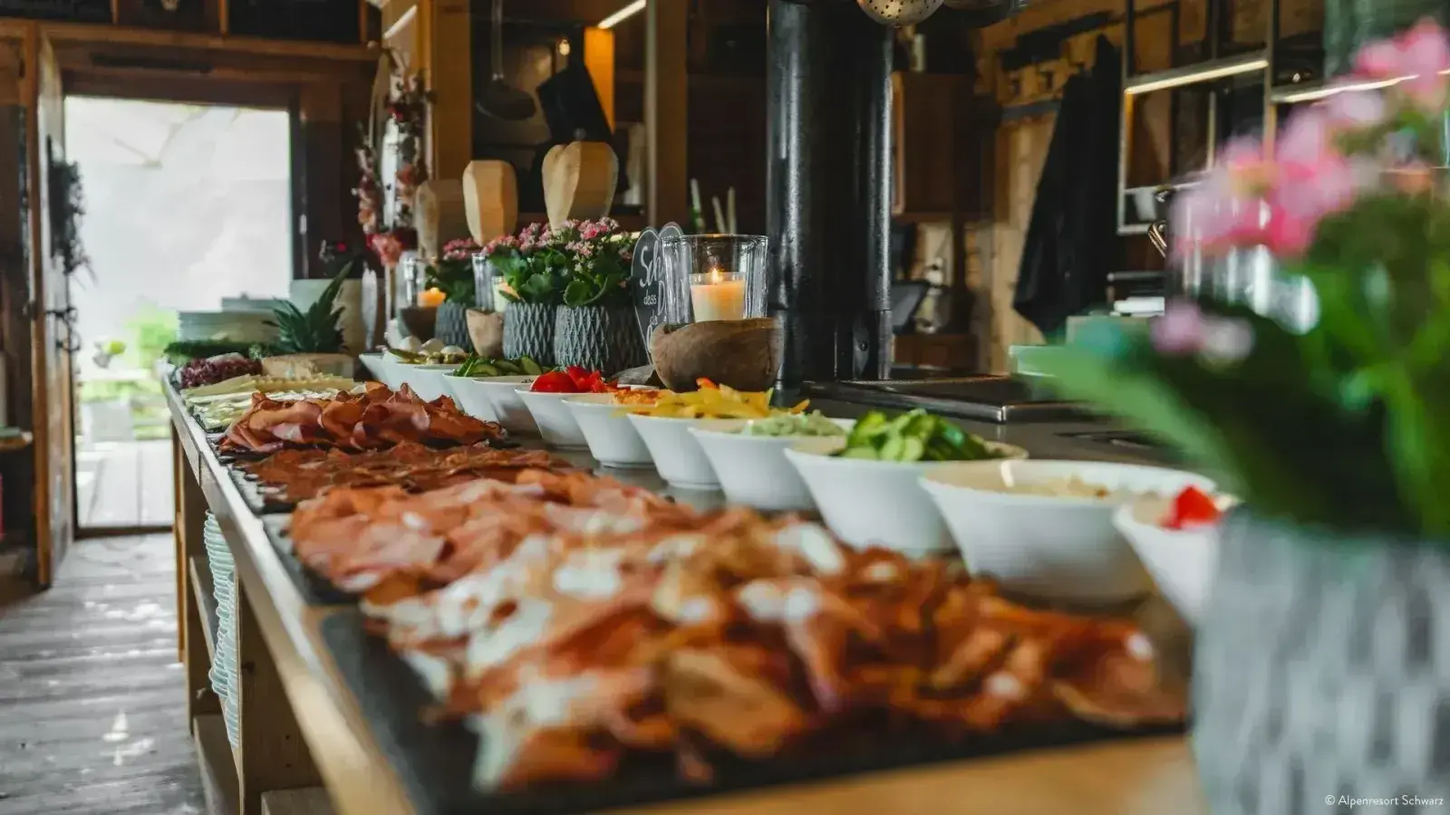 Hut brunch buffet with cold cuts, salads and a candle in the cosy alpine parlour of the Stöttlalm in Tyrol